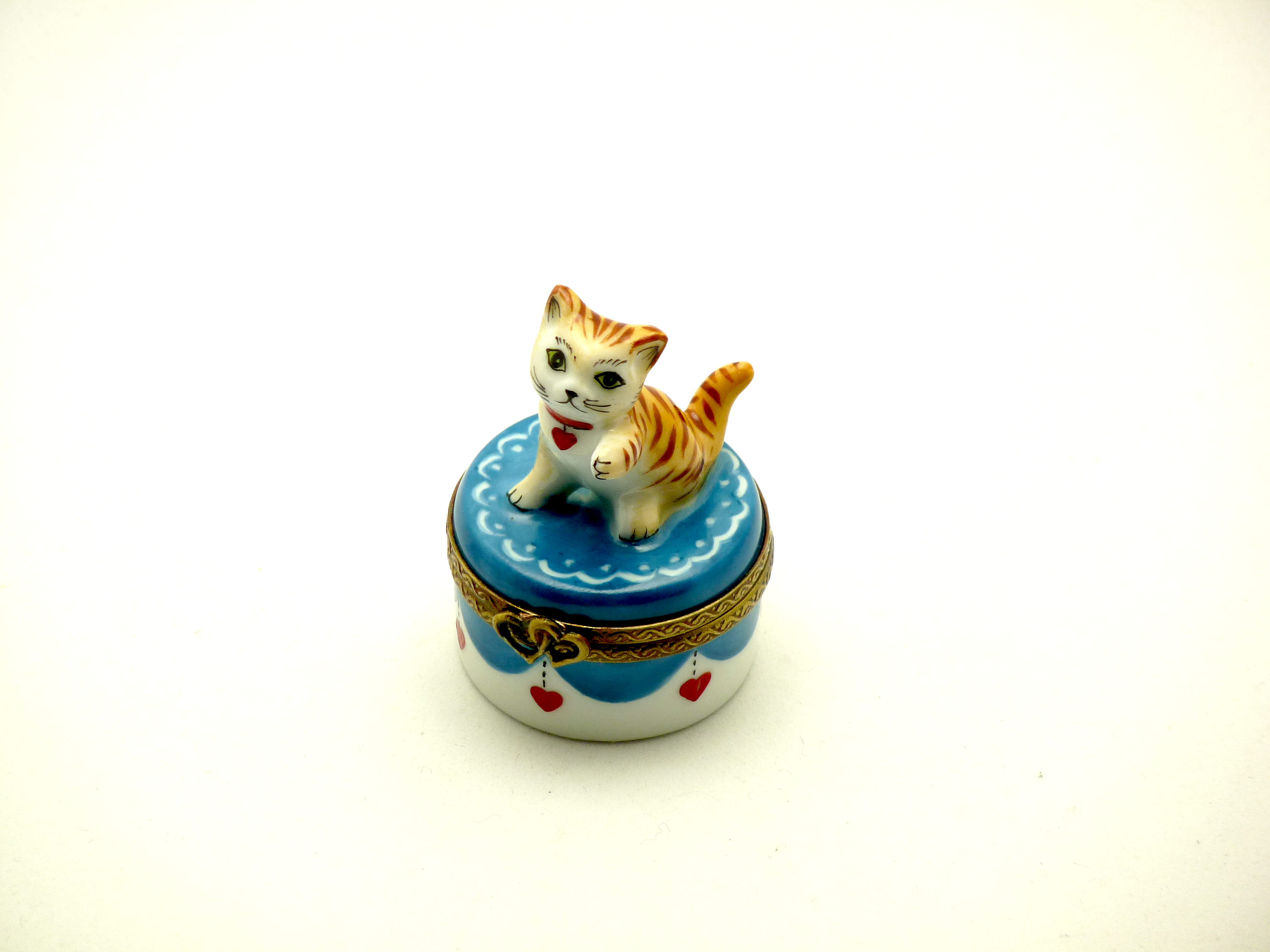 Small kitten on round base with littles hearts
