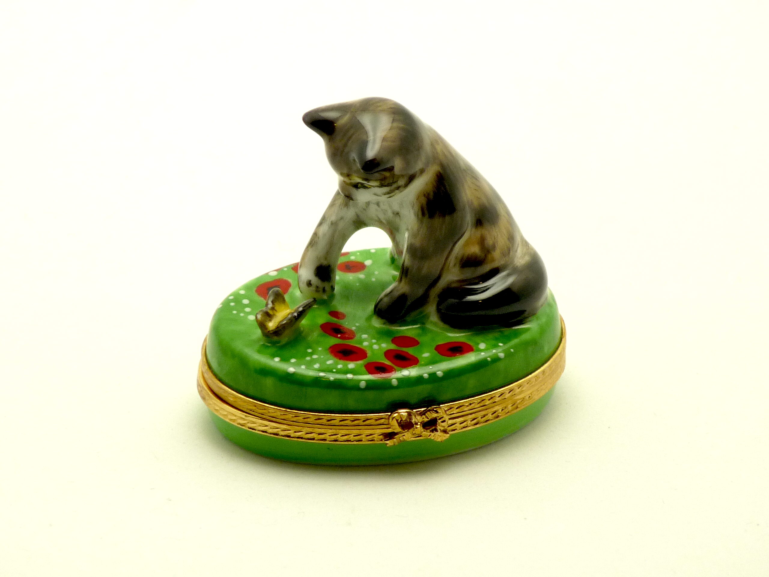 Cat playing with butterfly on oval base